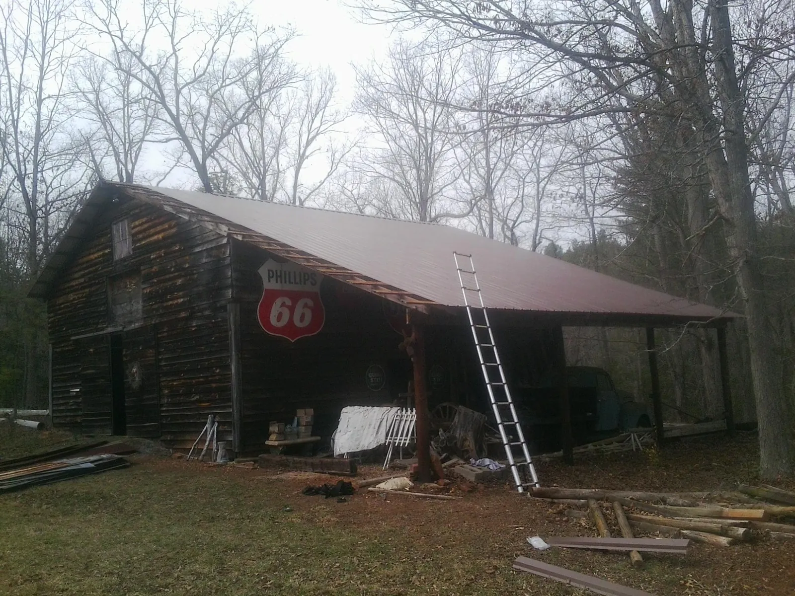 New metal roof on an open sided timber barn with a vintage sign in Ontario