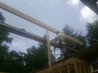 Carpenter setting a ridge beam over a new addition frame — Ice Dam Removal by Roofing Brothers in Ontario